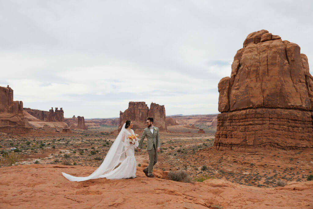 Bride and Groom in front of red rock background in Moab Utah