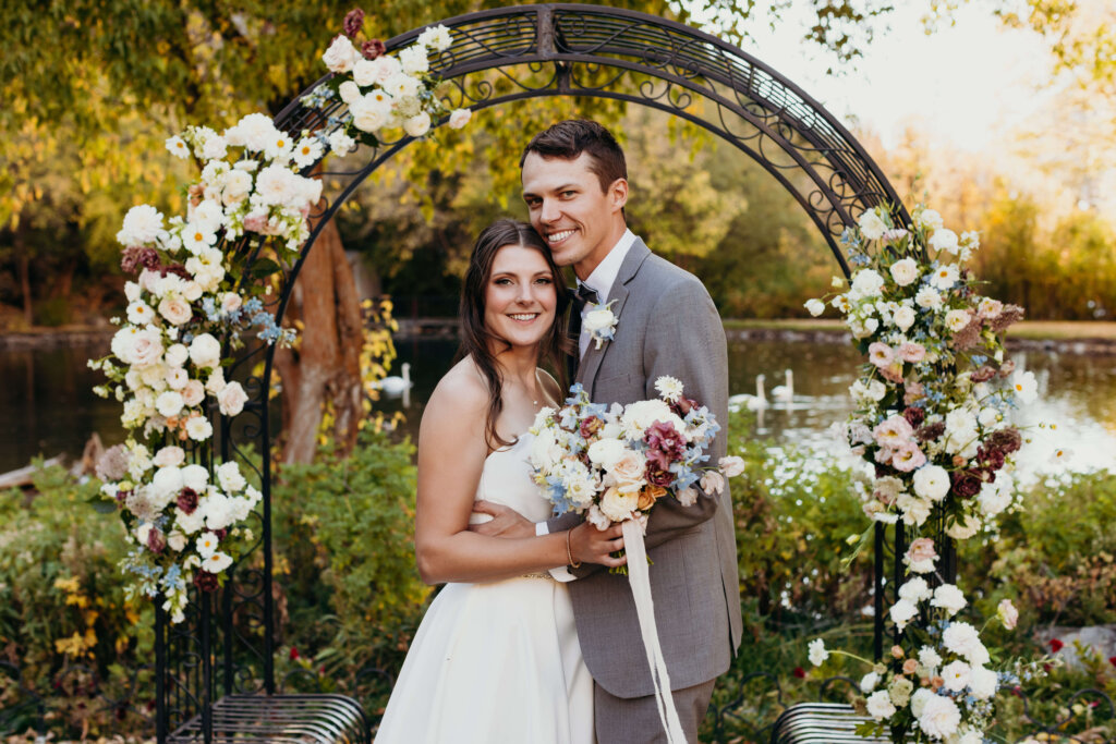 Bride and Groom posing in front of wedding arch as part of Utah mountain wedding